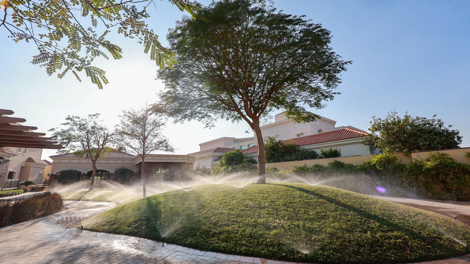 Irrigation sprinklers watering a landscaped villa garden