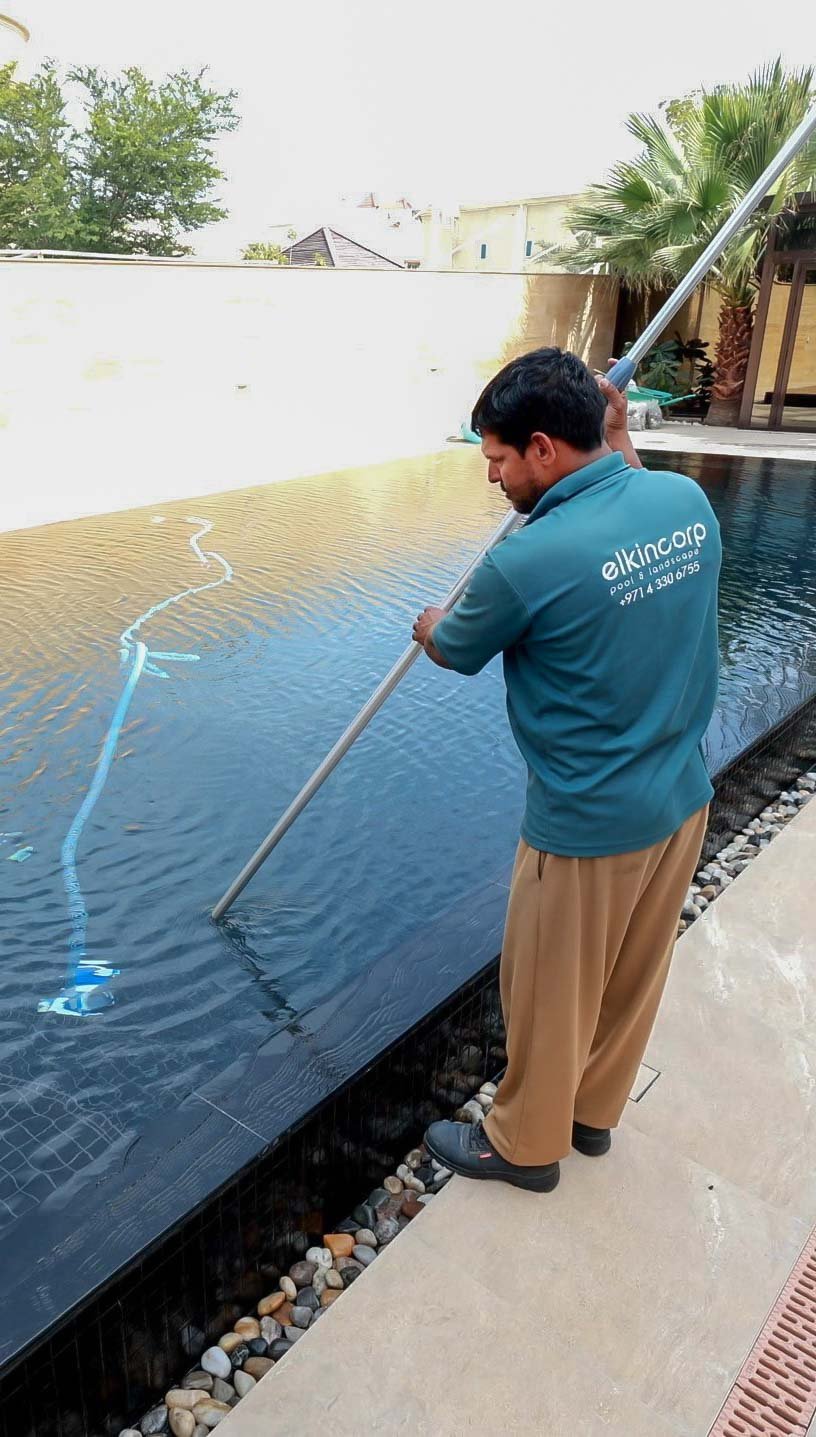 Elkin Corp pool technician skimming a private pool